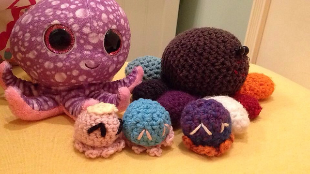 Ollie the Octopus (top left store-bought plushie) was my high school senior mascot, so of course I crocheted some mini octokids (Princess is pink, Cotton Candy is blue, and Beelzebub is purple). The rainbow guy in the back is Kumquatz (I made him in middle school).